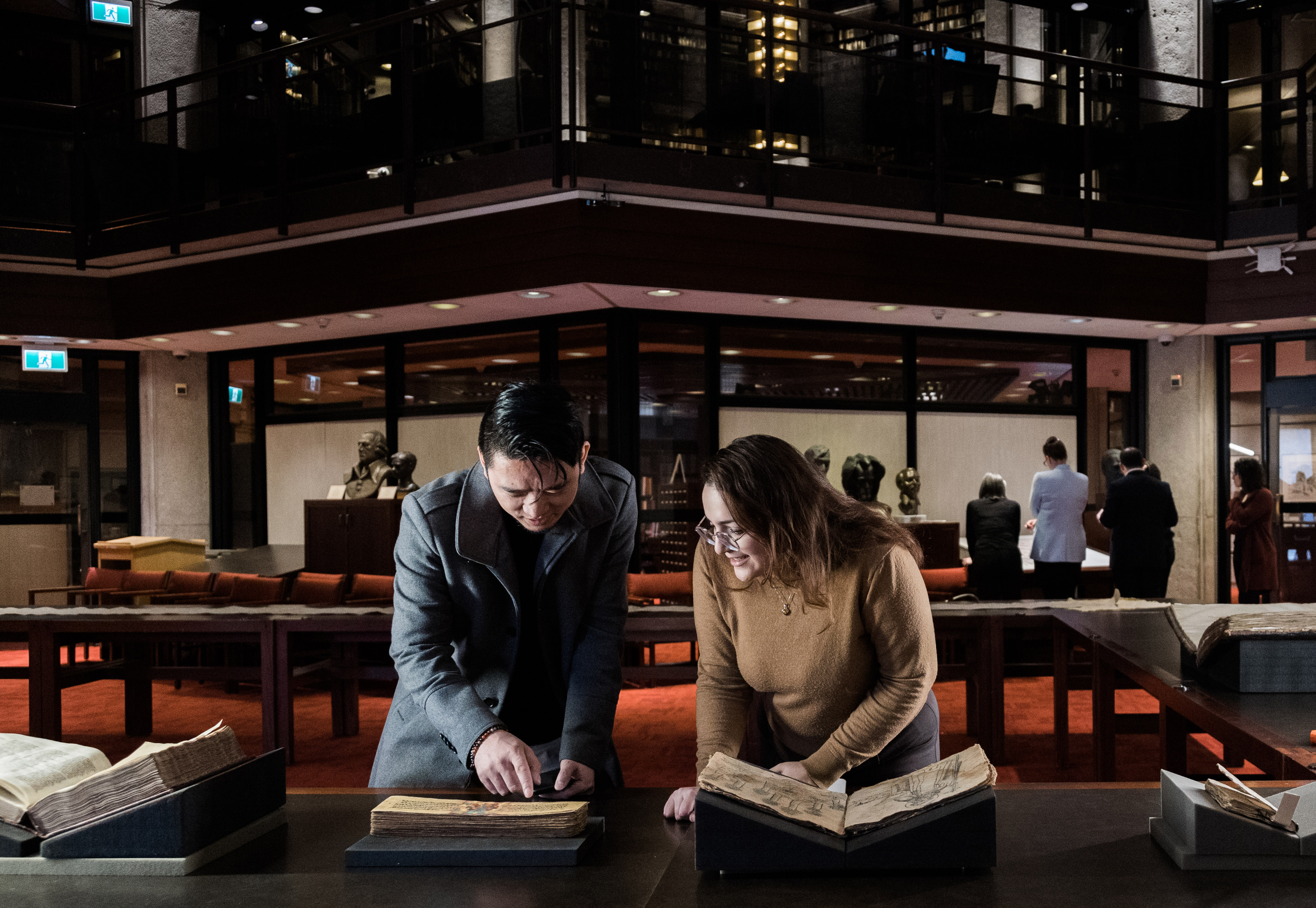 Students looking at books in the Fisher Library's seminar room