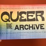 Hand holding Queer Archive poster