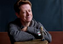 Photograph of Richard Harte with figurine of James Joyce