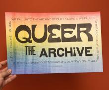 Hand holding Queer Archive poster